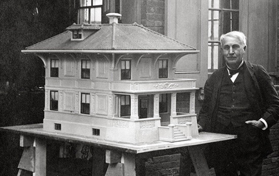 Photo of Thomas Edison with a model of one of his concrete homes.